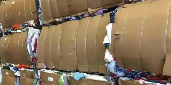Bales of used clothing stacked in a warehouse, ready for export